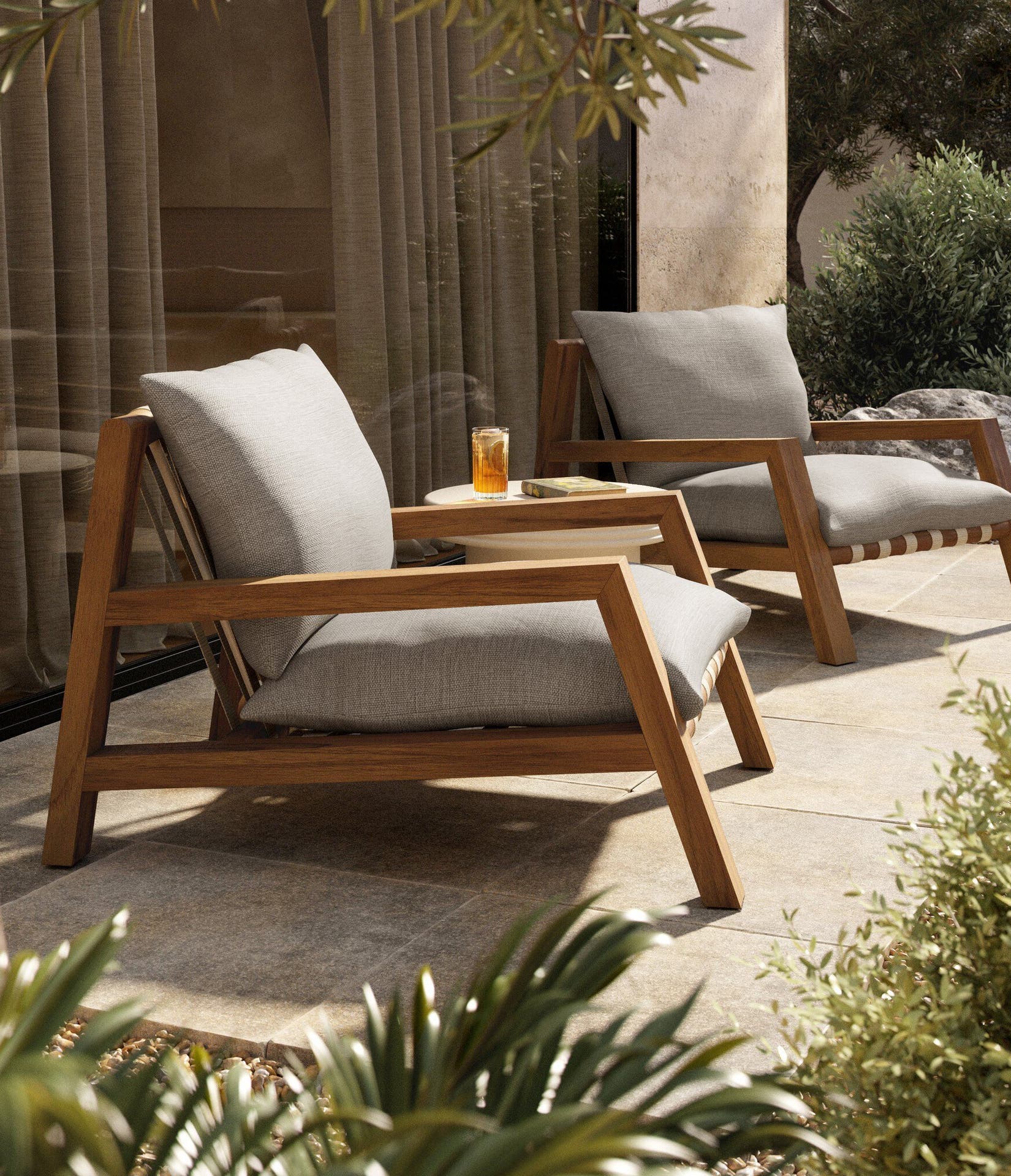 Two outdoor lounge chairs with grey plush cushions and wood frame. 