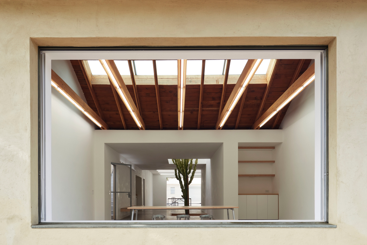 Image through a window revealing a white, minimalist space