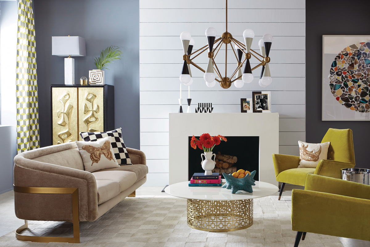 Ultra-modern living room with yellow chairs, cream sofa and chandelier with white fireplace in background