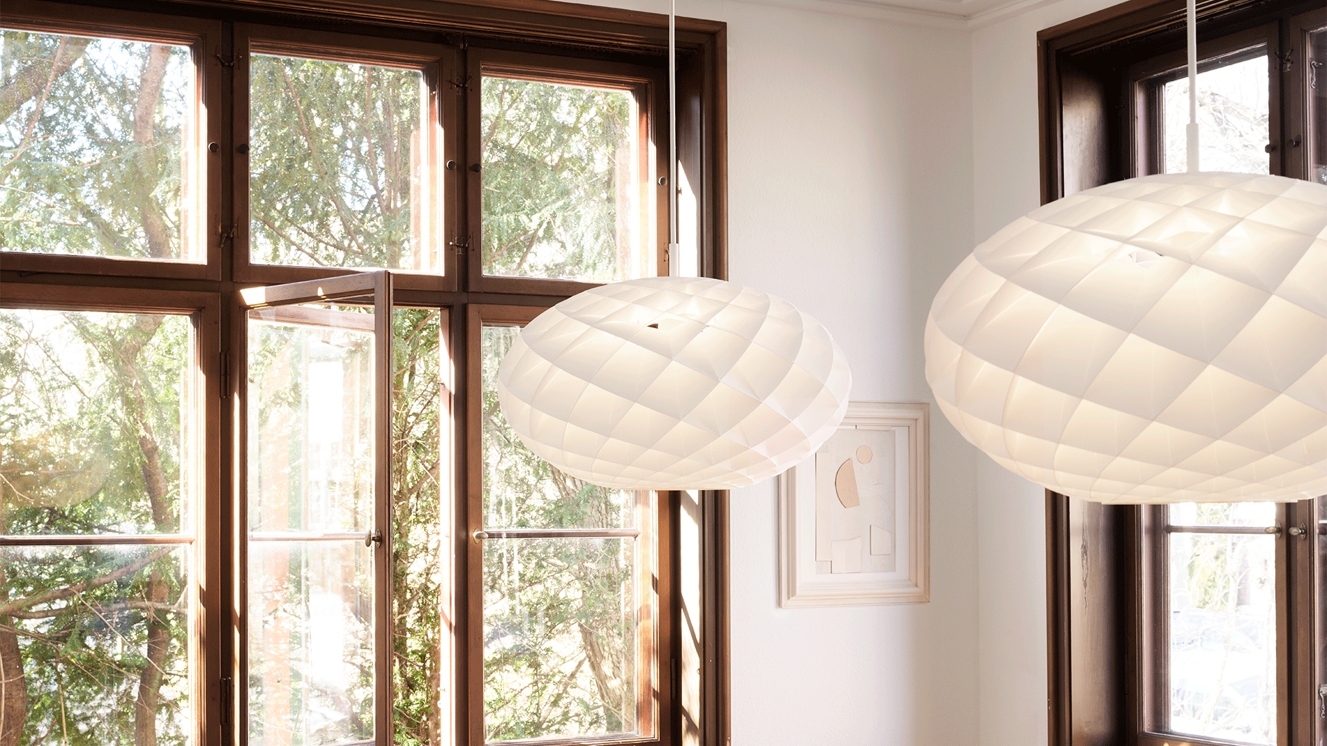 Louis Poulsen Patera Oval Pendants hanging in front of a window