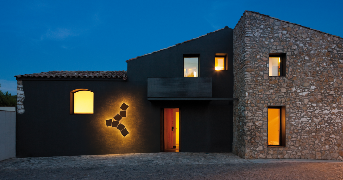 Outdoor wall sconce lighting on the exterior of a home at sunset