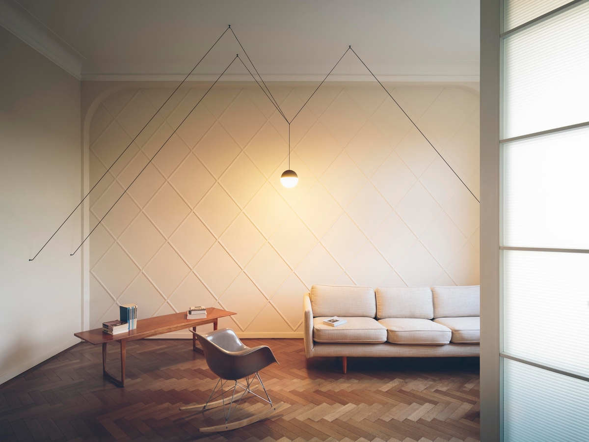 Angular pendant light in beige room with wood floors