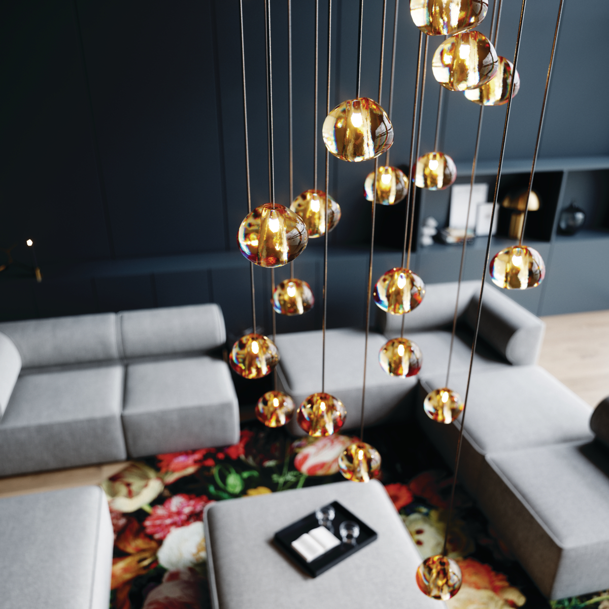 Gold globe lighting shot from above, over flower rug and gray sectional sofa