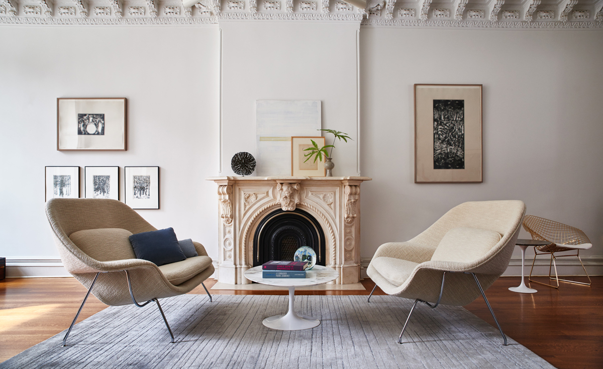 Two Saarinen Womb Lounge Chairs around a fireplace.