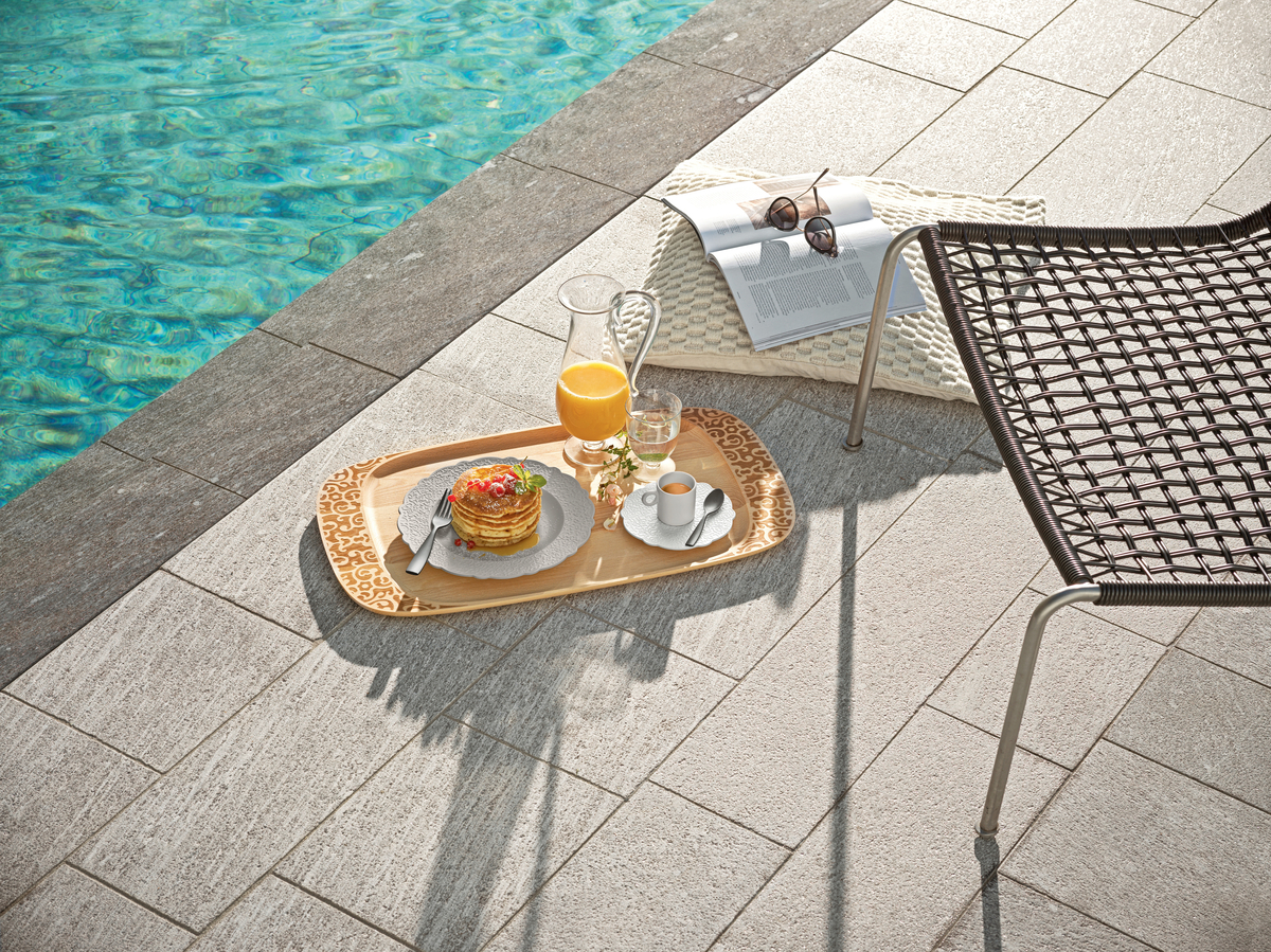 Poolside dining scene with orange juice and stack of small pancakes