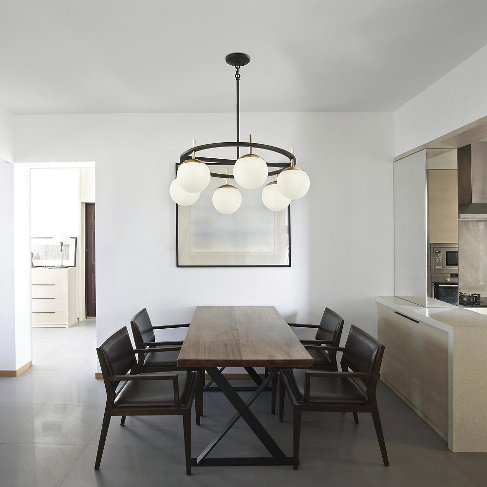 A sleek dining room and kitchen beneath chandelier.