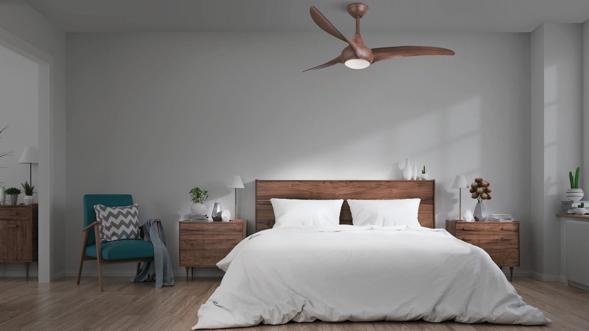 A ceiling fan with an LED over a simple bedroom.
