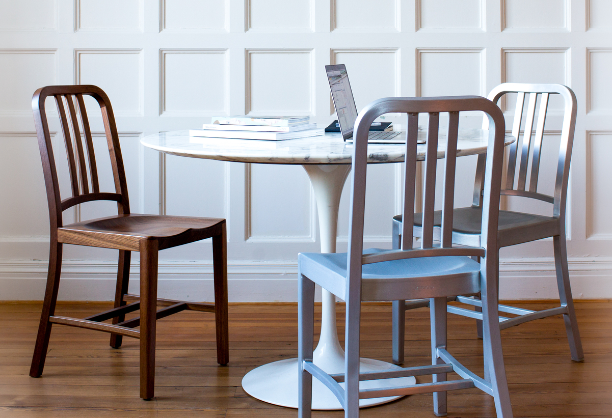 A group of Navy Chairs around a small dining table.