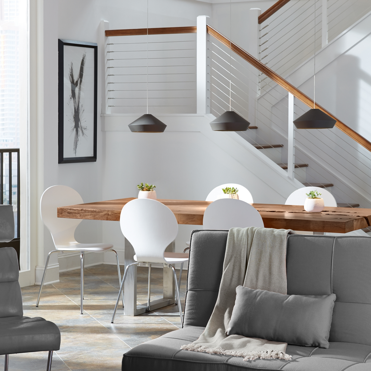 A clean dining space with hanging pendants.