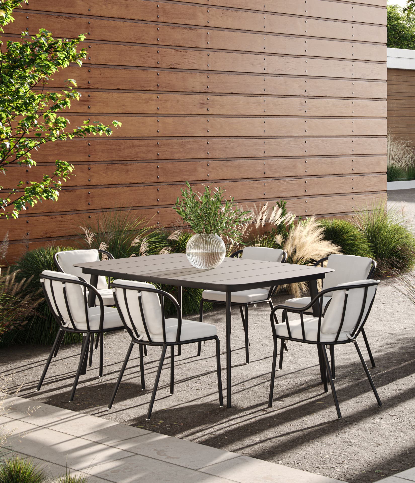 Outdoor dining set with a dark rectangle table and six chairs with light colored cushions. 