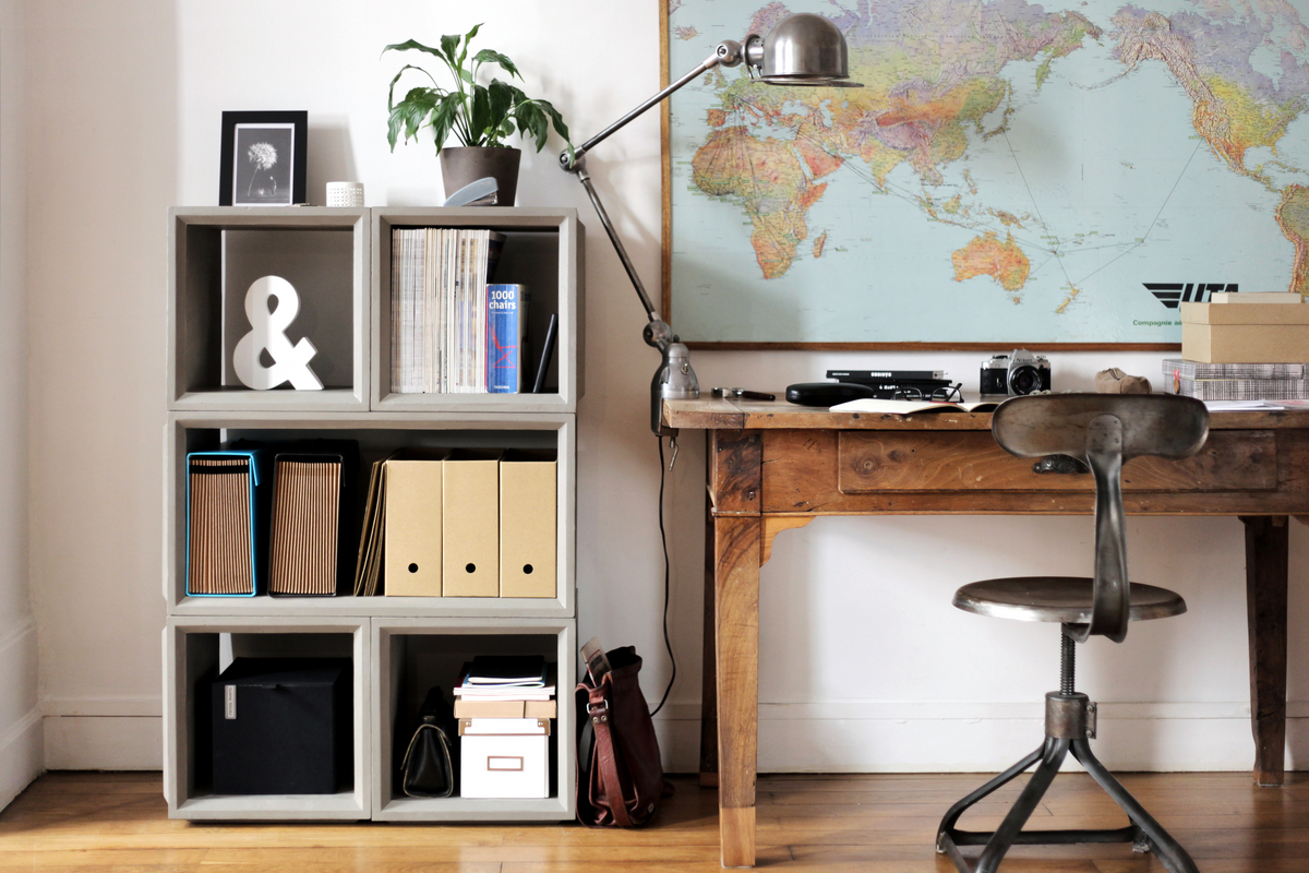 Vintage wooden desk with small storage cubicle and world map on wall