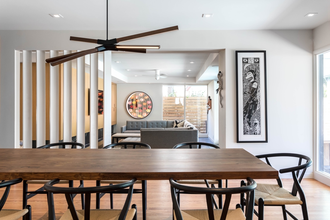 Sky Bang LED Chandelier above a large dining table.