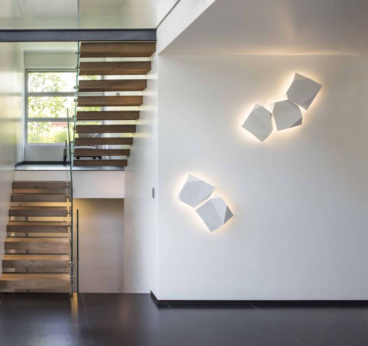 Wall lighting on white wall near wooden staircase with window
