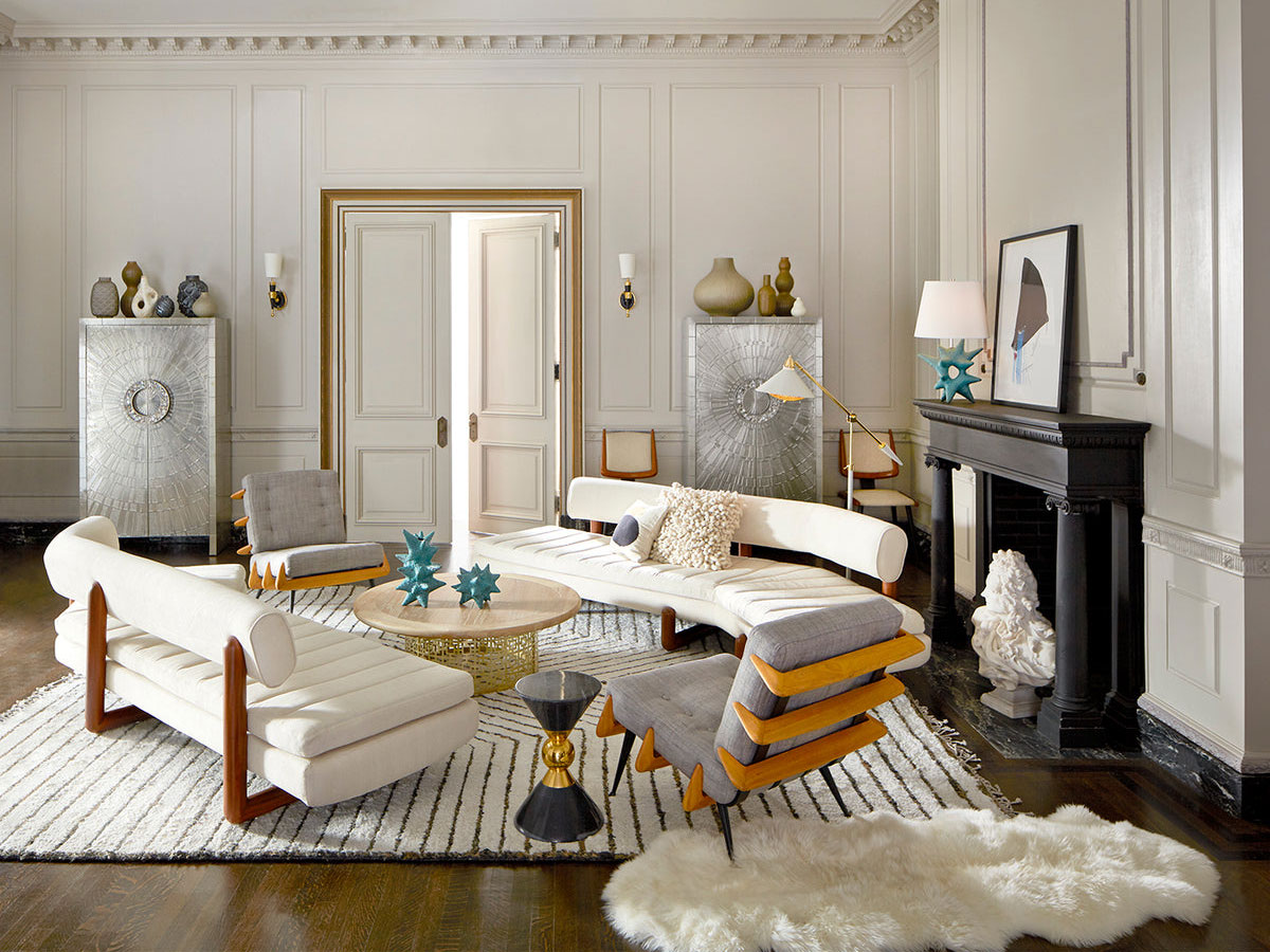 White sofas over black and white striped area rug in white high-ceilinged living space