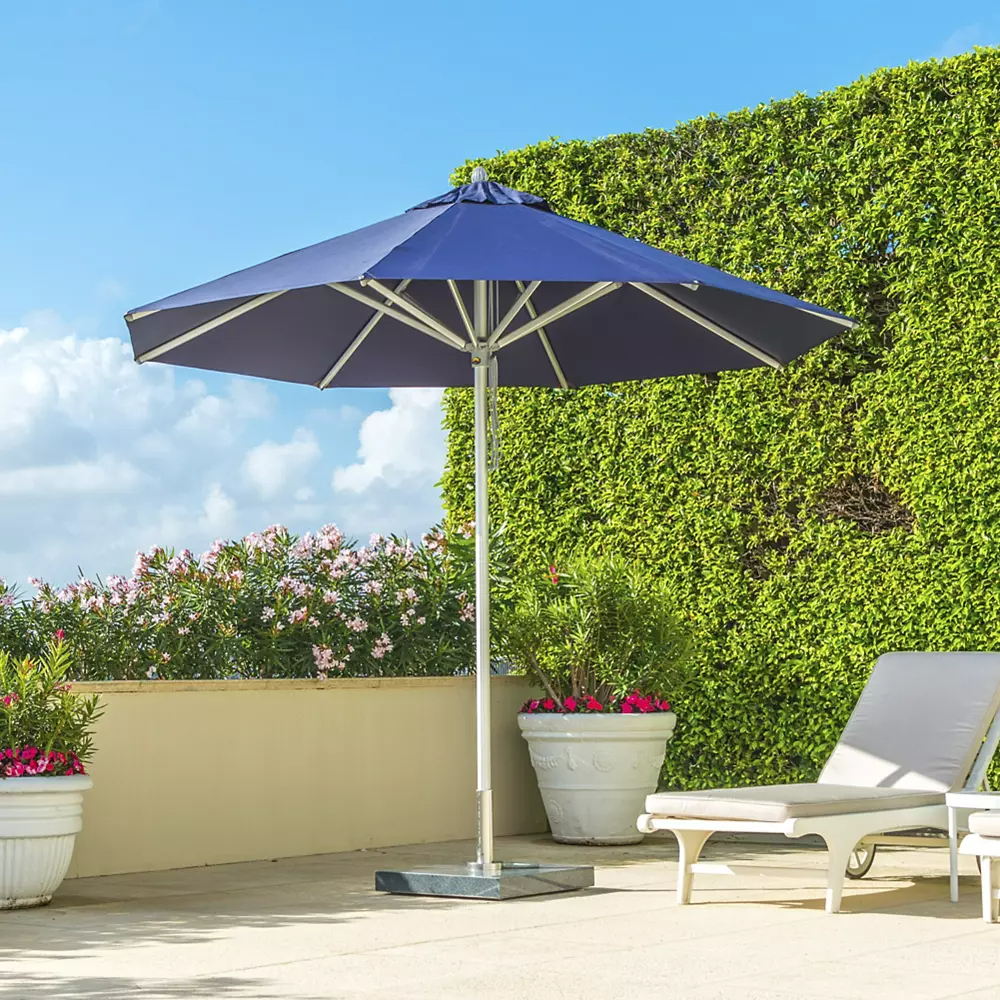 Outdoor umbrella with pool lounge and green plant wall