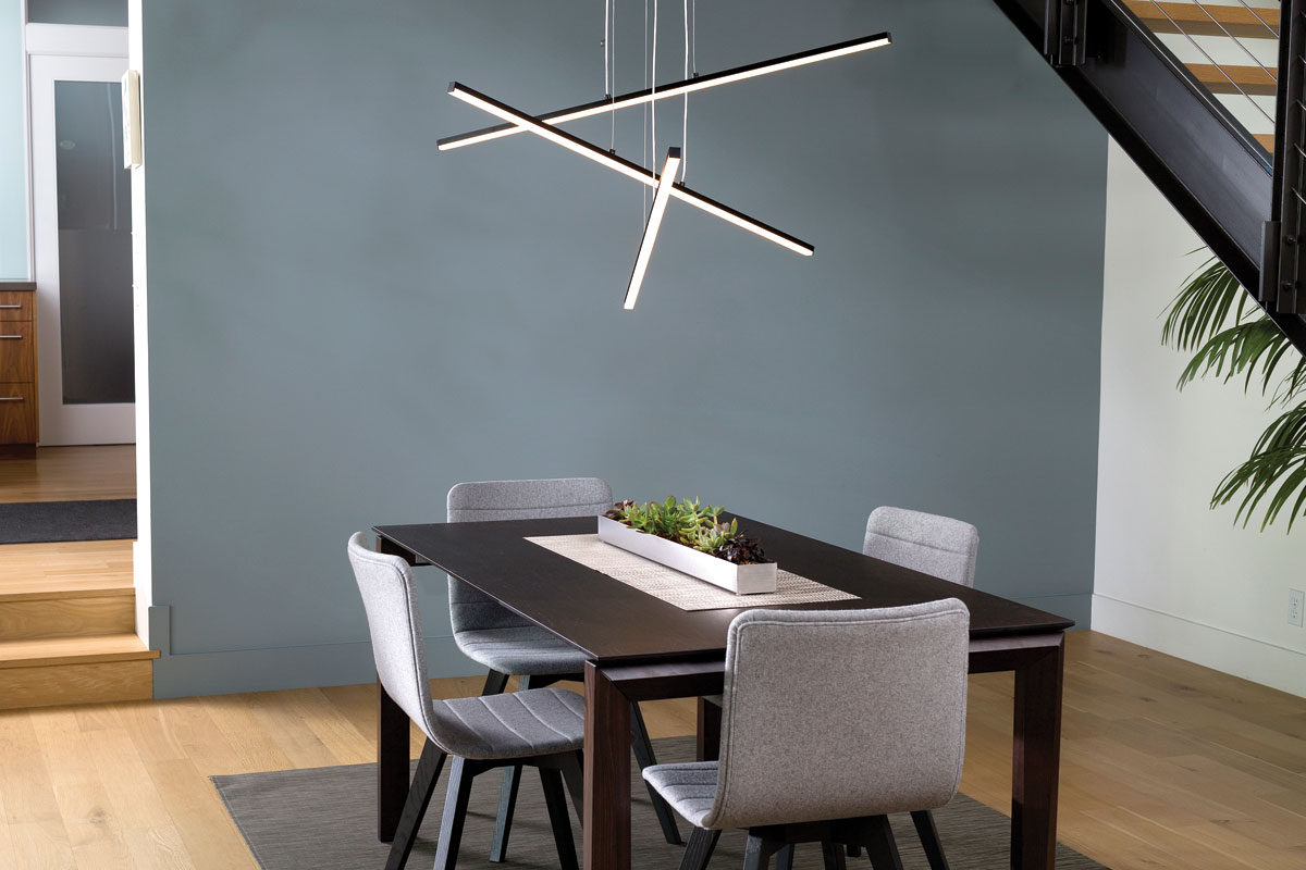Three-bar lighting fixture over wooden dining table