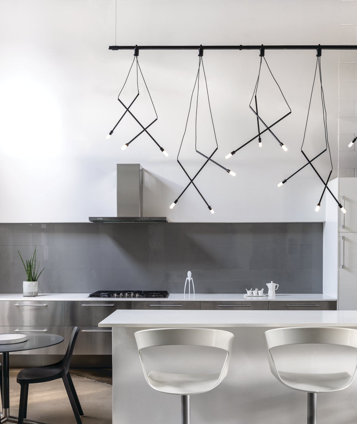 Angular black lighting over white island in kitchen 