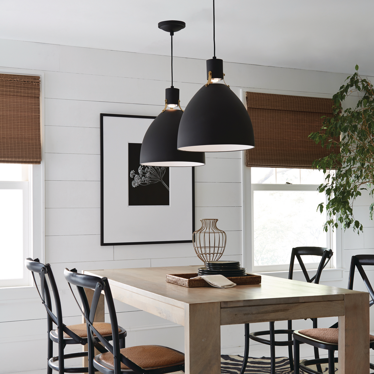 A pair of large hanging lamps over a dining room table.