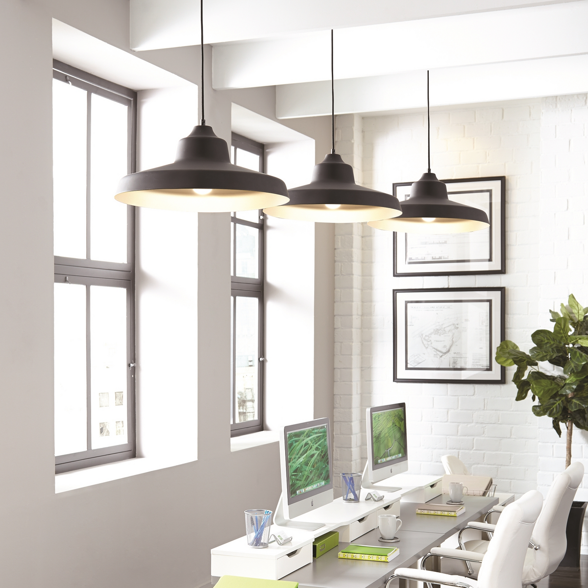 Three black pendants over a white co-working space